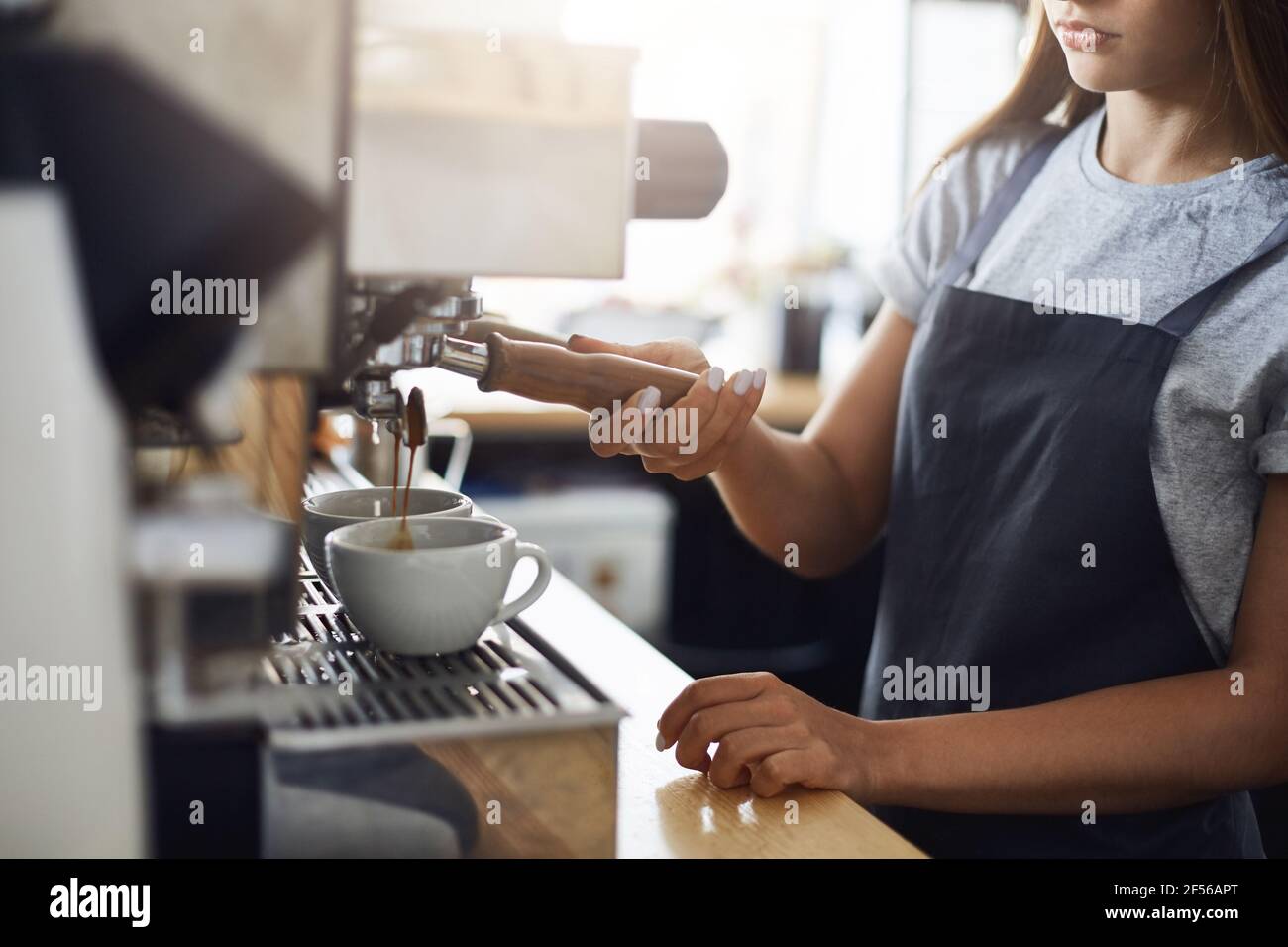 Close up of espresso shots pouring into cups. Delicious coffee to start your day. Stock Photo