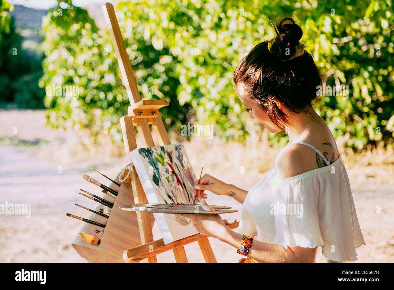 Young woman artist painting on easel Stock Photo - Alamy