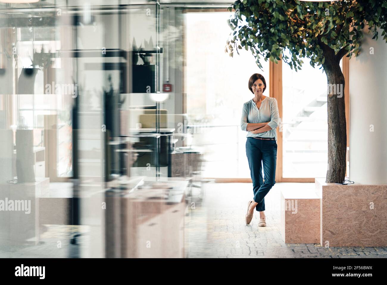 Woman crossed legs standing office hi-res stock photography and images ...