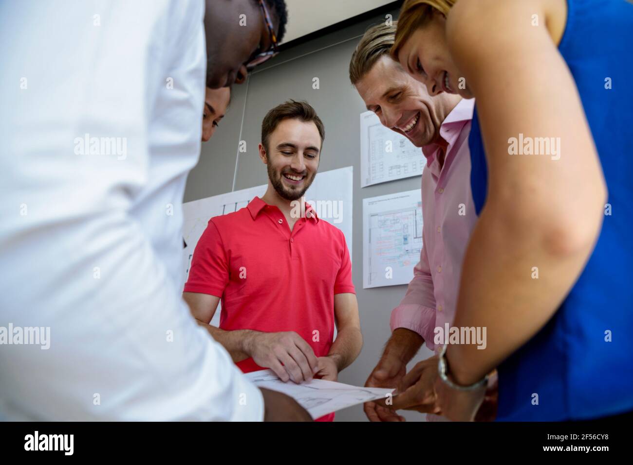 Smiling business people working on graph together in board room Stock Photo