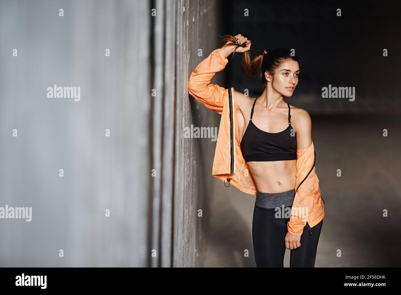 Attractive sporty girl with perfect body wear activewear leggings, lean  concrete wall turn aside, smiling pleased and motivated, finish productive  Stock Photo - Alamy