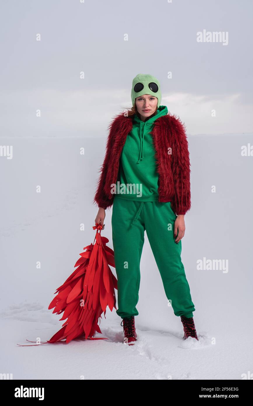 Woman in green bird costume holding wings against sky Stock Photo