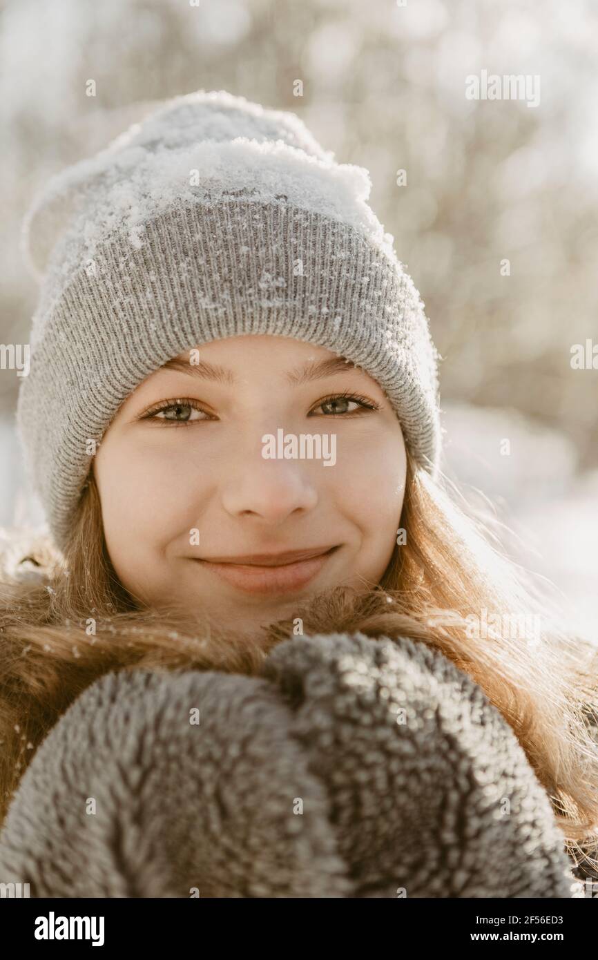 Portrait of beautiful teenage girl wearing knit hat smiling at camera