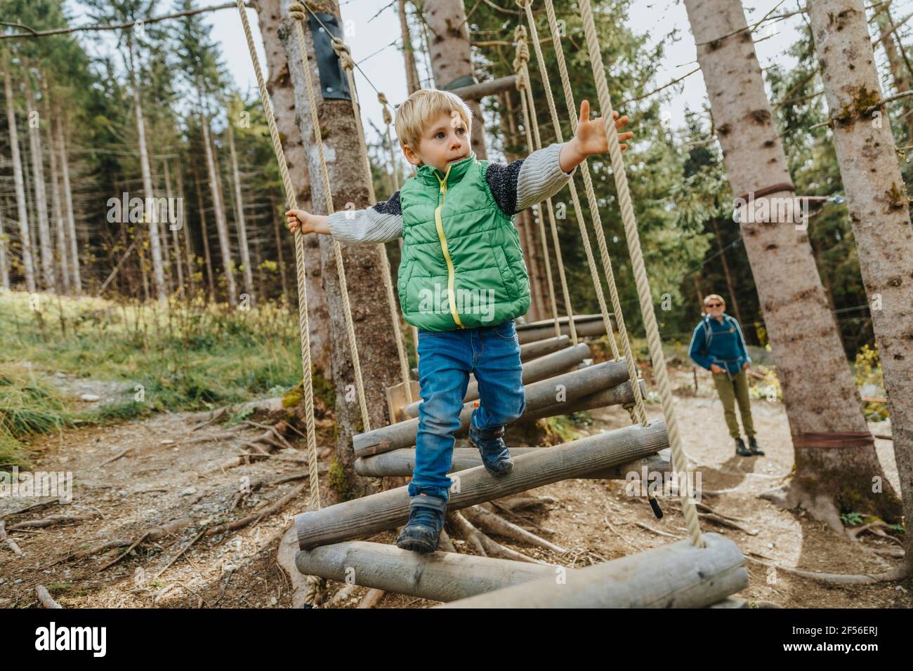 Boy looking away while doing rope course in forest at Salzburger Land, Austria Stock Photo