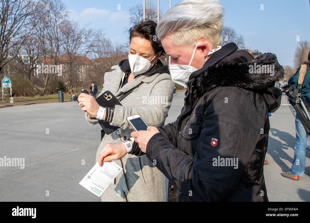Berlin, Germany. 24th Mar, 2021. Spectators Christiane Gerlach (l) and  Nadine Nehls scan the QR codes of their Corona quick tests in front of the  Max-Schmeling-Halle using the wristbands handed out. The