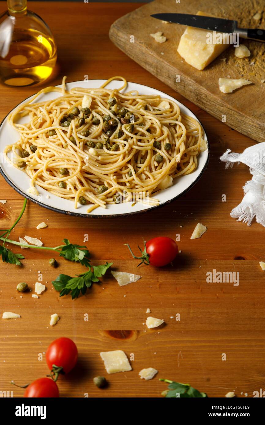 Man pouring olive oil on spaghetti in plate Stock Photo