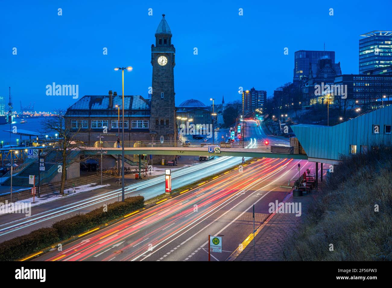 Germany, Hamburg, Vehicle light trails in front of Saint Pauli Piers clock tower at dawn Stock Photo