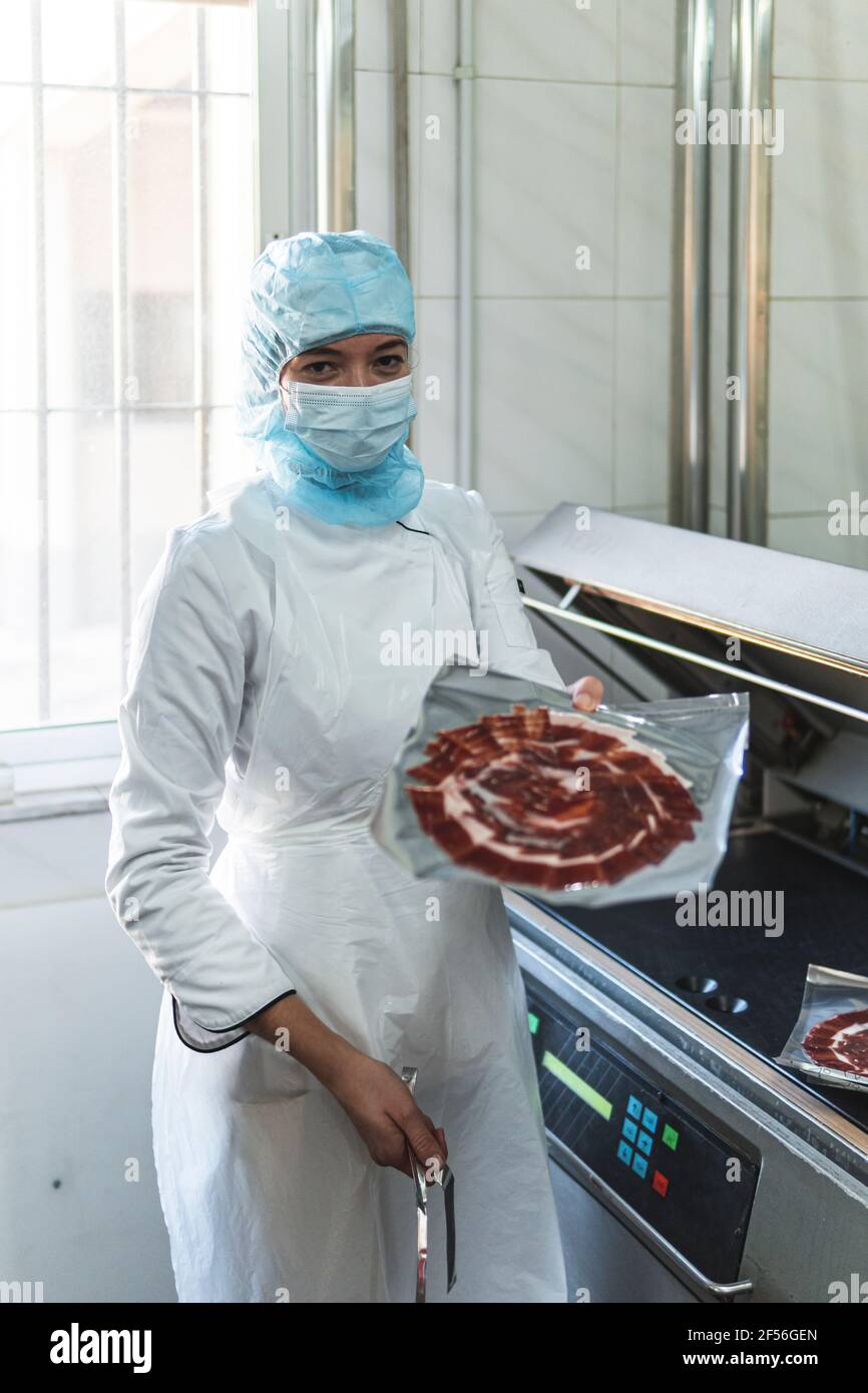 Employee holding package of meat in factory Stock Photo