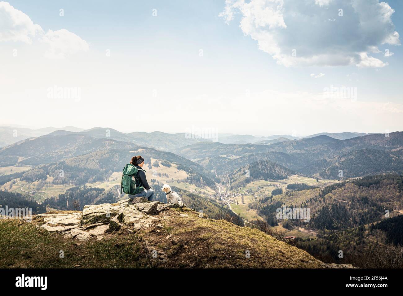 Female hiker looking at view while sitting on Kandel Mountain at Baden-Wurttemberg, Germany Stock Photo