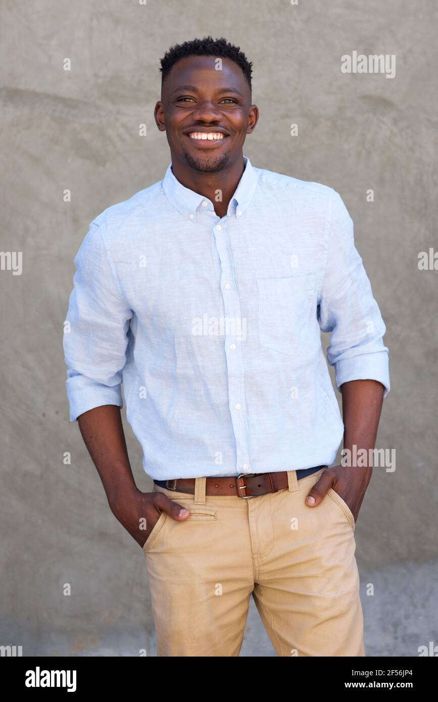 Portrait of handsome african american man smiling by wall Stock Photo ...
