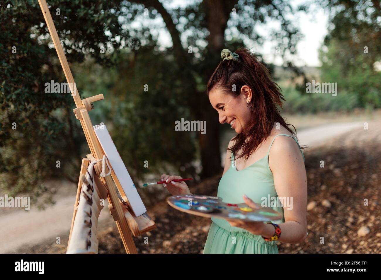 Young woman artist painting on easel Stock Photo - Alamy