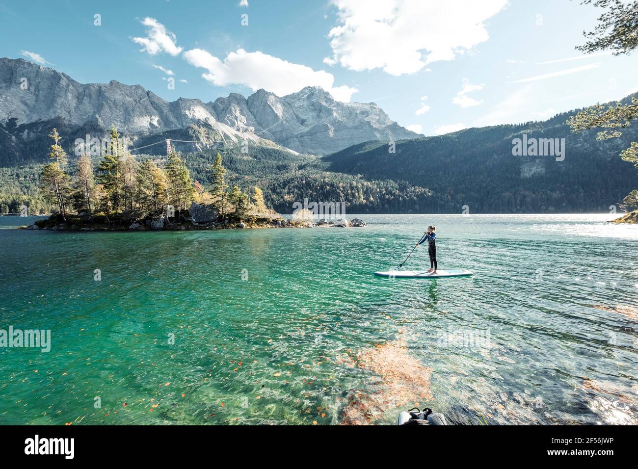 Germany, Bavaria, Garmisch Partenkirchen, Young woman stand up paddling