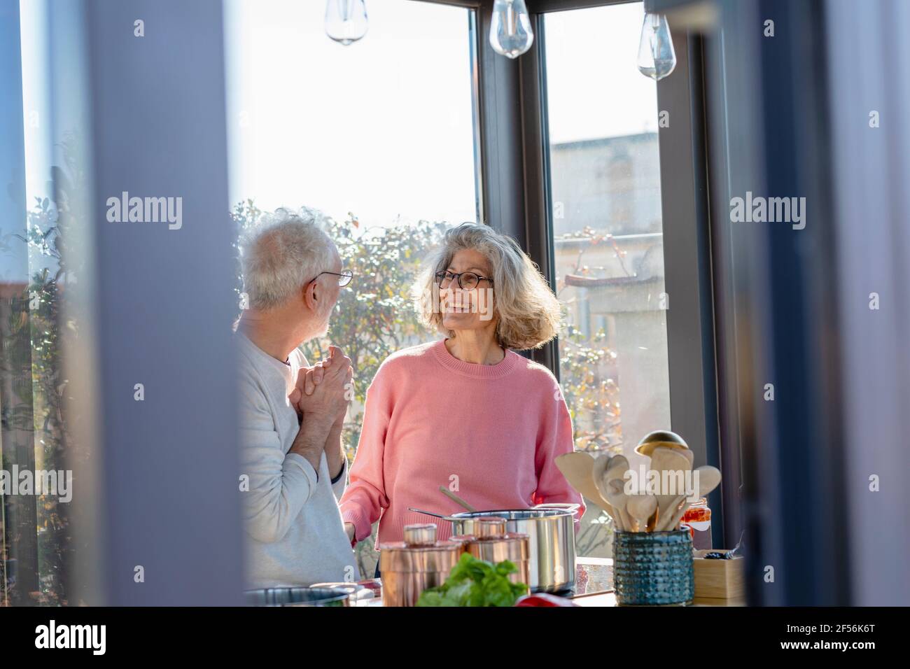 Senior couple looking at each other while standing at home Stock Photo