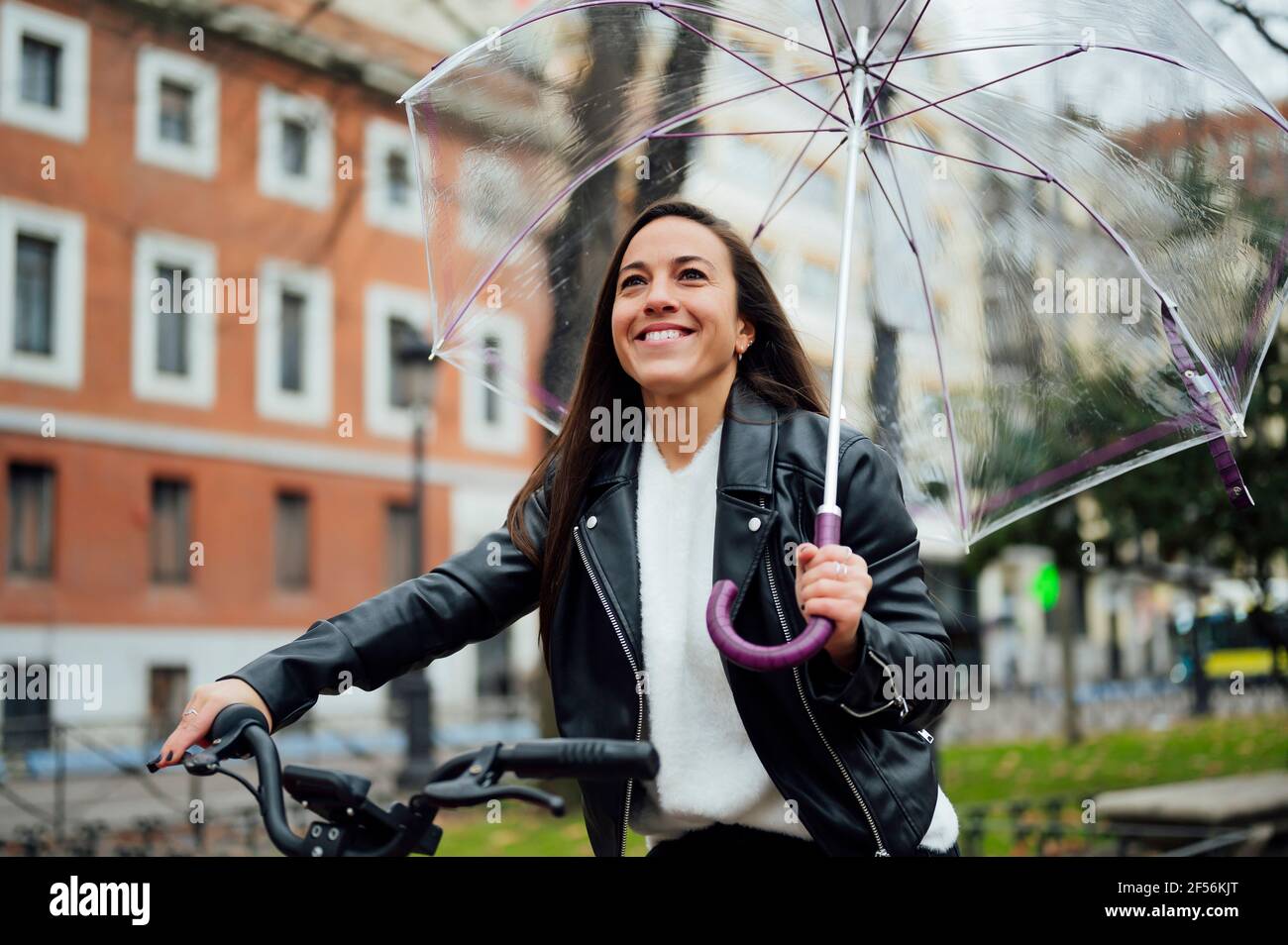 Woman riding bicycle holding umbrella hi-res stock photography and images -  Alamy