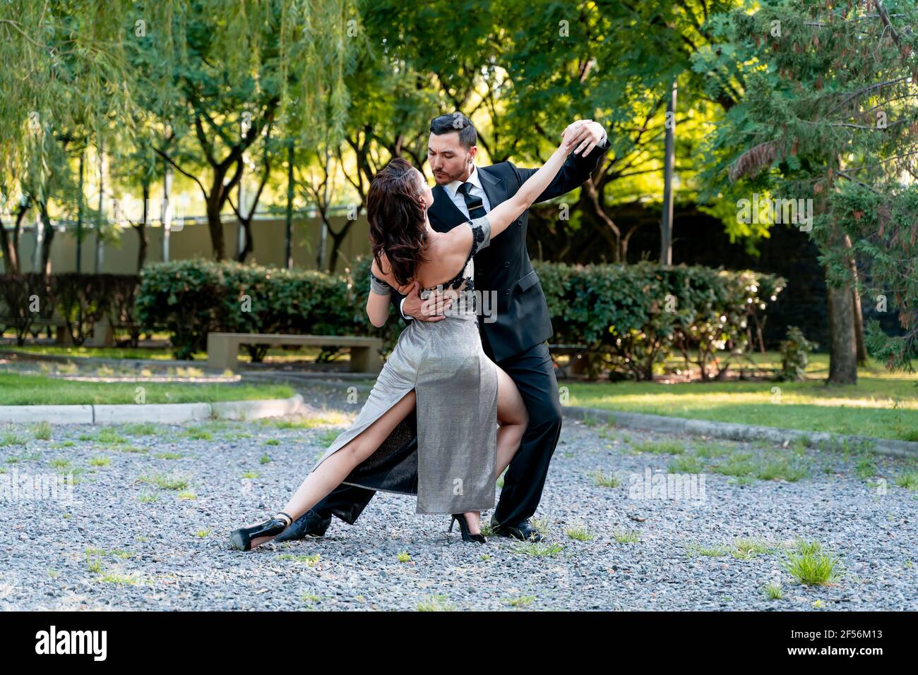 Flexible female practicing with male dancer in public park Stock Photo