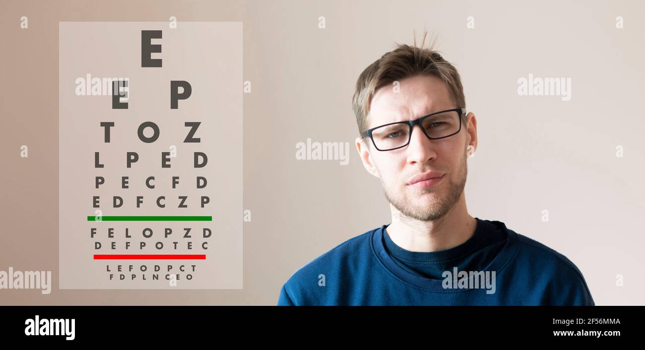 a young man check the eyesight vision, examine the health with test letters chart Stock Photo