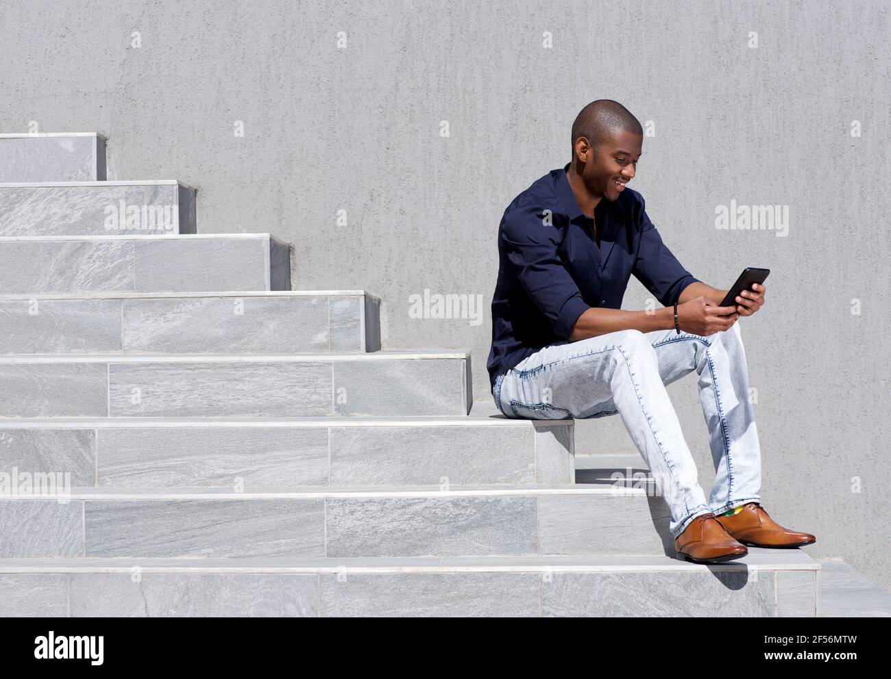 Man sitting stairs using tablet hi-res stock photography and images - Alamy