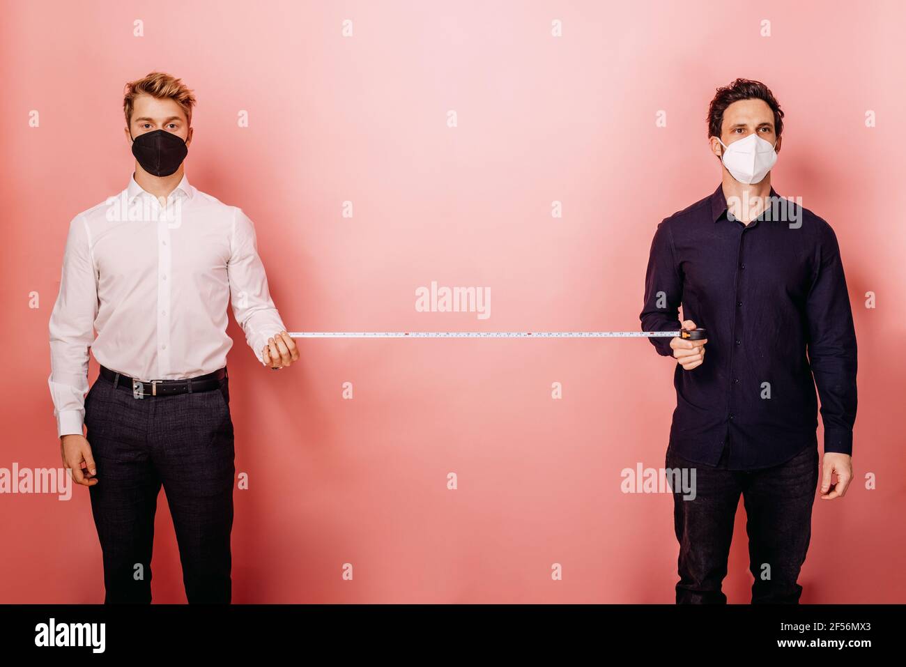 Business people measuring social distance with measuring tape while ...