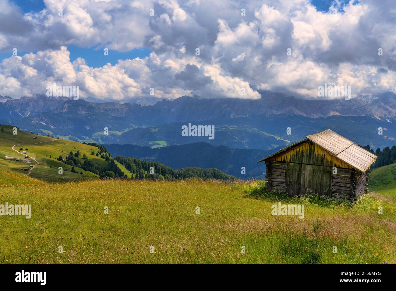 Dramatic clouds over lone hut at Odle mountain range during summer Stock Photo