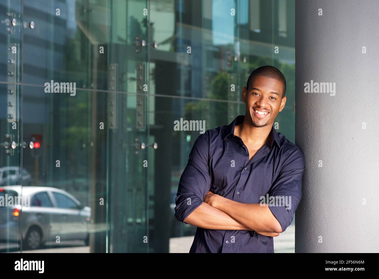 Portrait of confident young black man smiling with arms crossed Stock ...