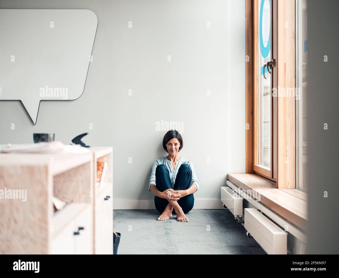 Smiling female entrepreneur with hands clasped in office Stock Photo