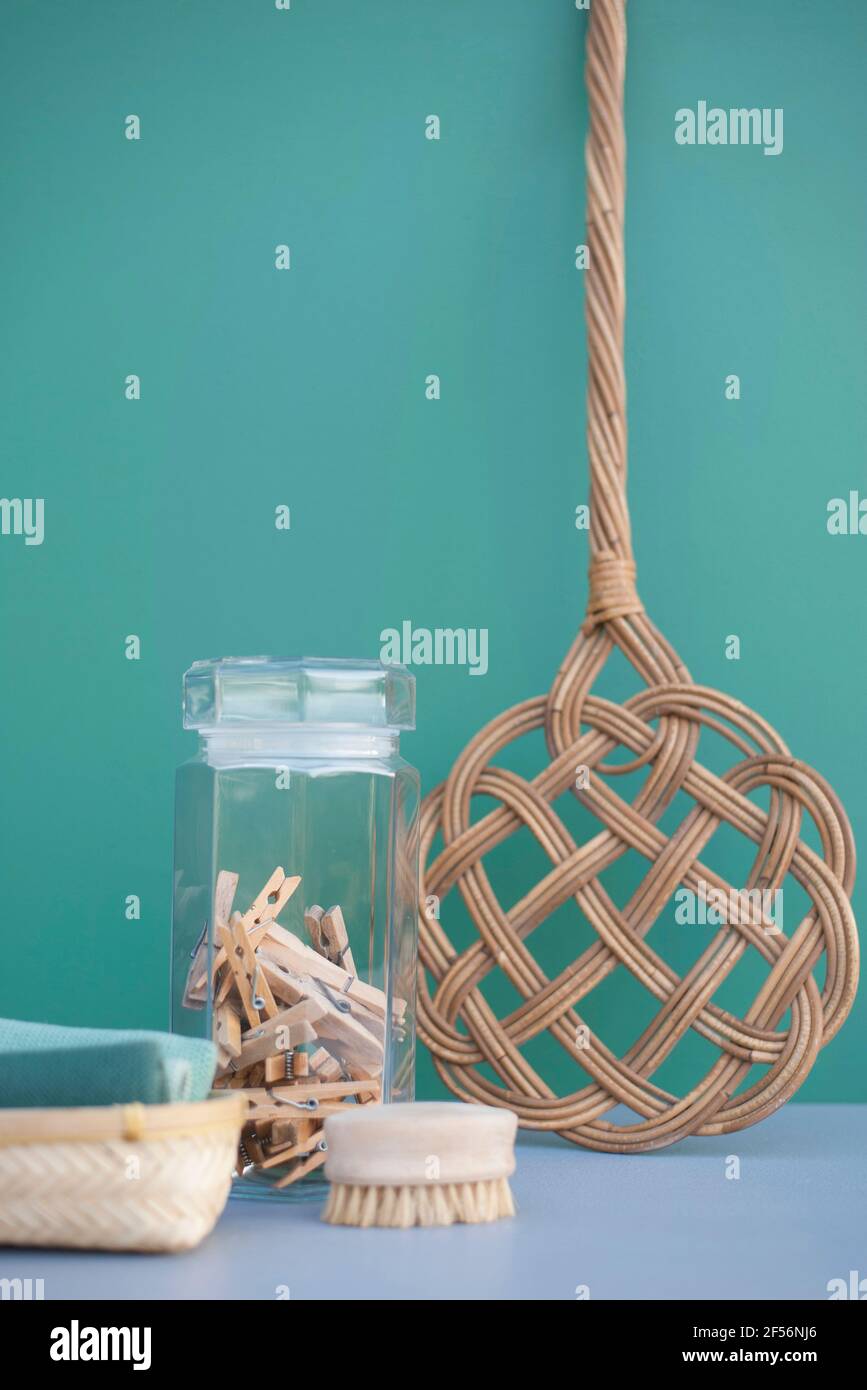 DIY cleaning supplies: retro carpet beater, clothespins in jar, cotton rags and wooden brush Stock Photo