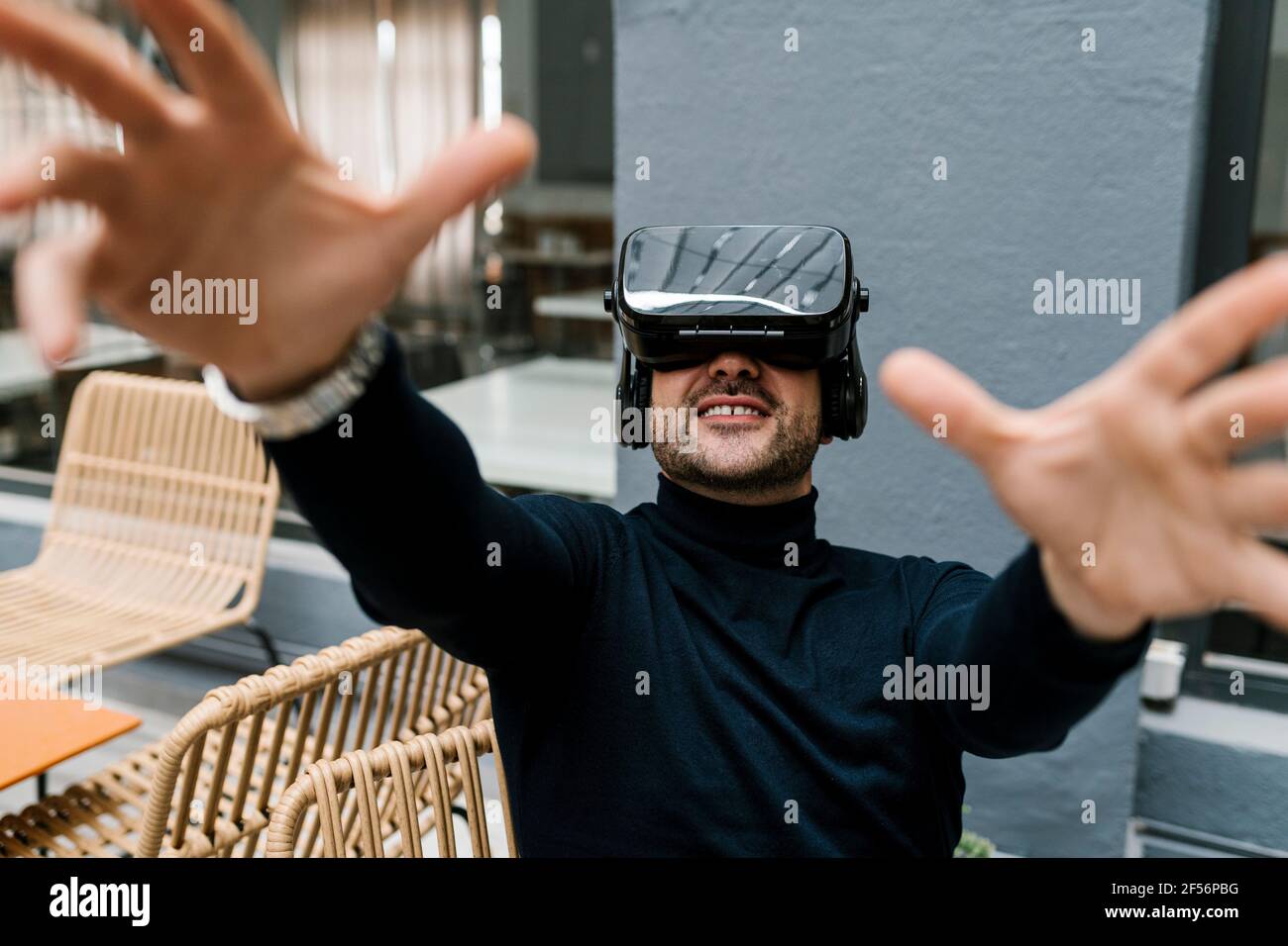 Businessman using virtual reality headset while sitting at cafe Stock Photo