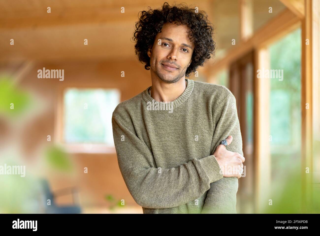 Curly hair man staring while standing at spacious room Stock Photo