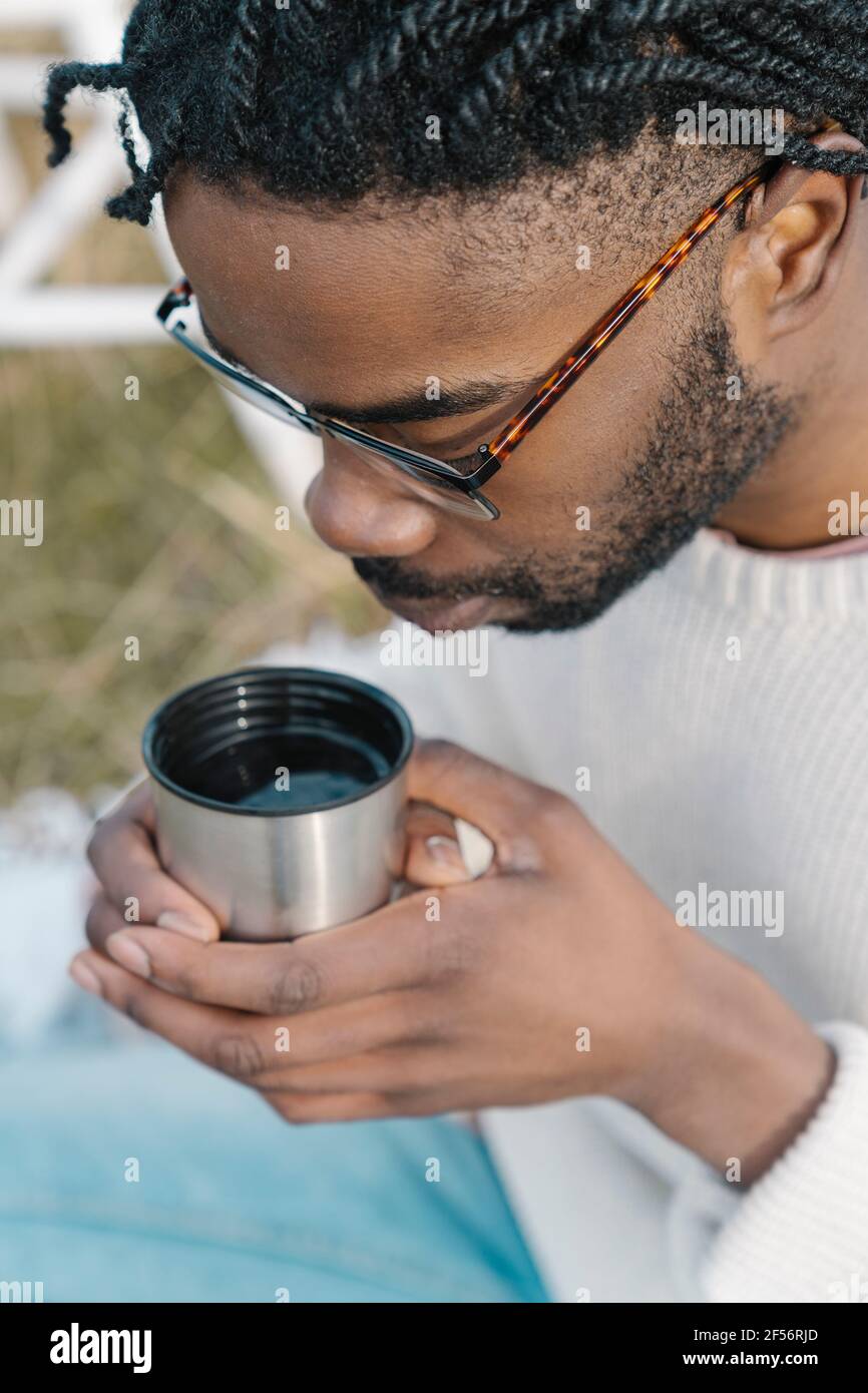 Young man drinking hot tea from cup Stock Photo