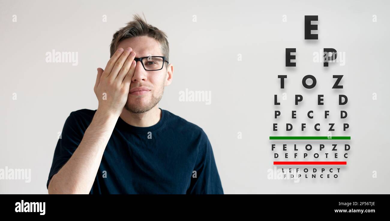 a young man check the eyesight vision, examine the health with test letters chart Stock Photo