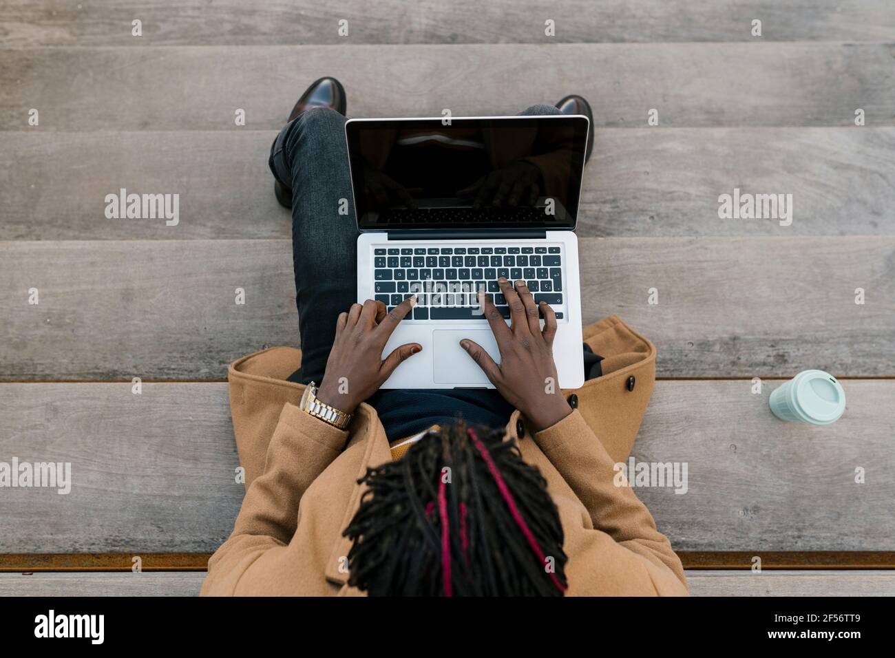 Man using laptop while sitting on steps Stock Photo