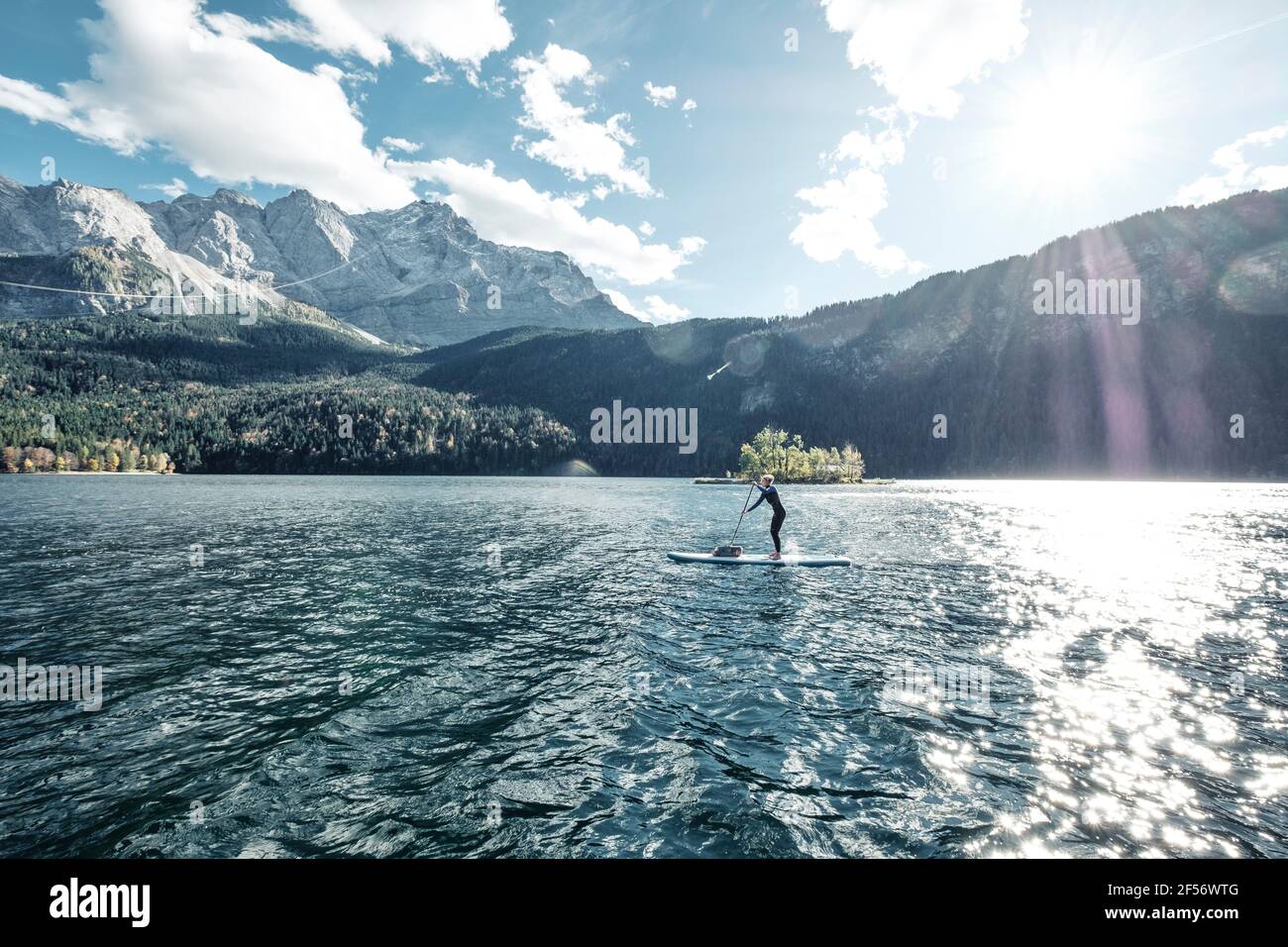 Germany, Bavaria, Garmisch Partenkirchen, Young woman stand up paddling