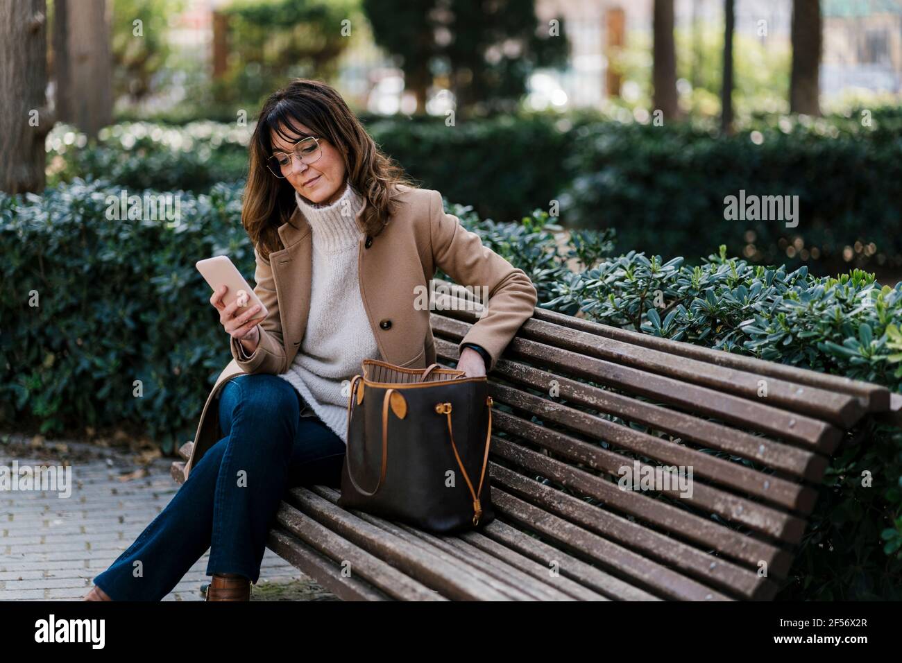Mature woman on park bench hi-res stock photography and images - Alamy