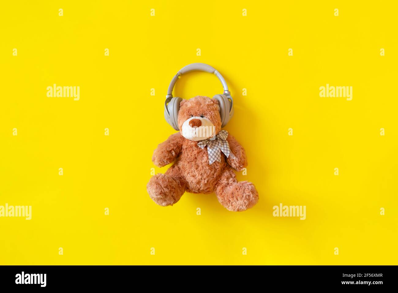 a teddy bear in headphones listen to the audio music radio Stock Photo -  Alamy