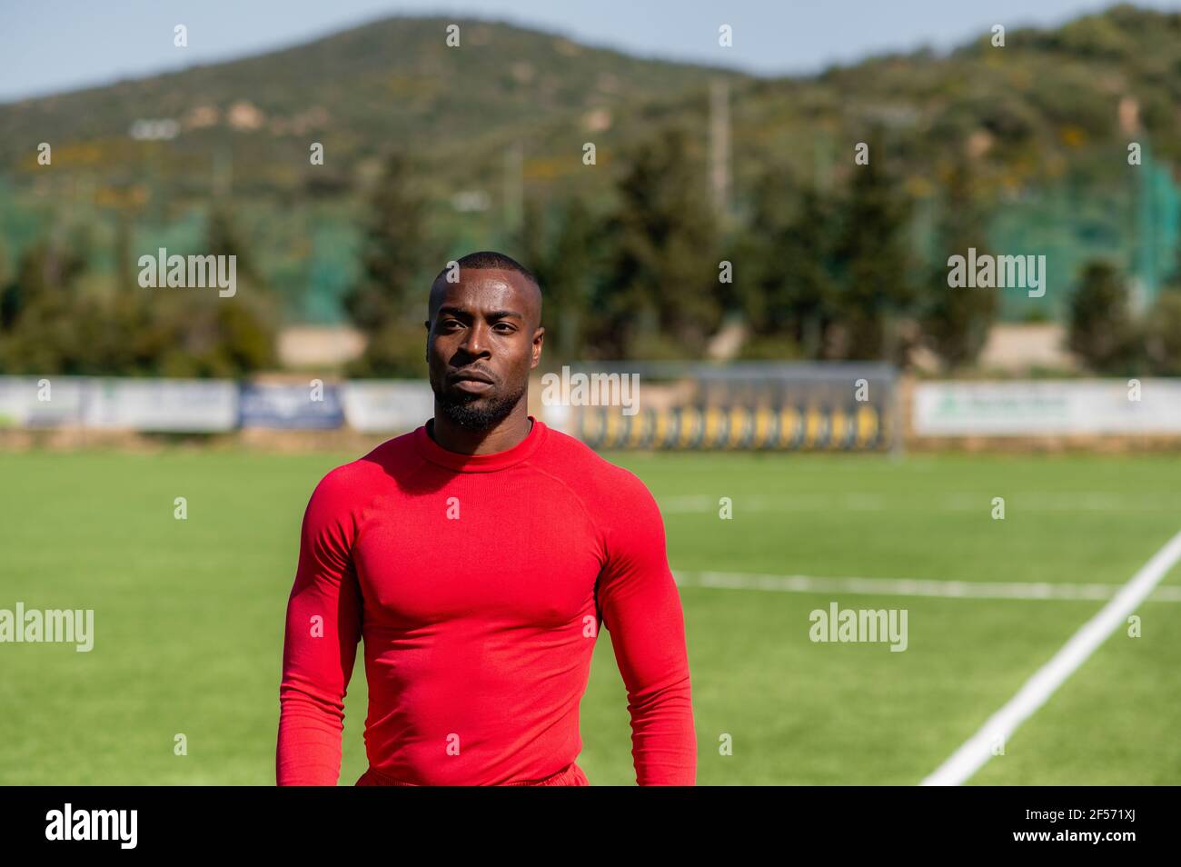 Medium shot portrait of African American sportsman athlete in running track with serious face. Stock Photo