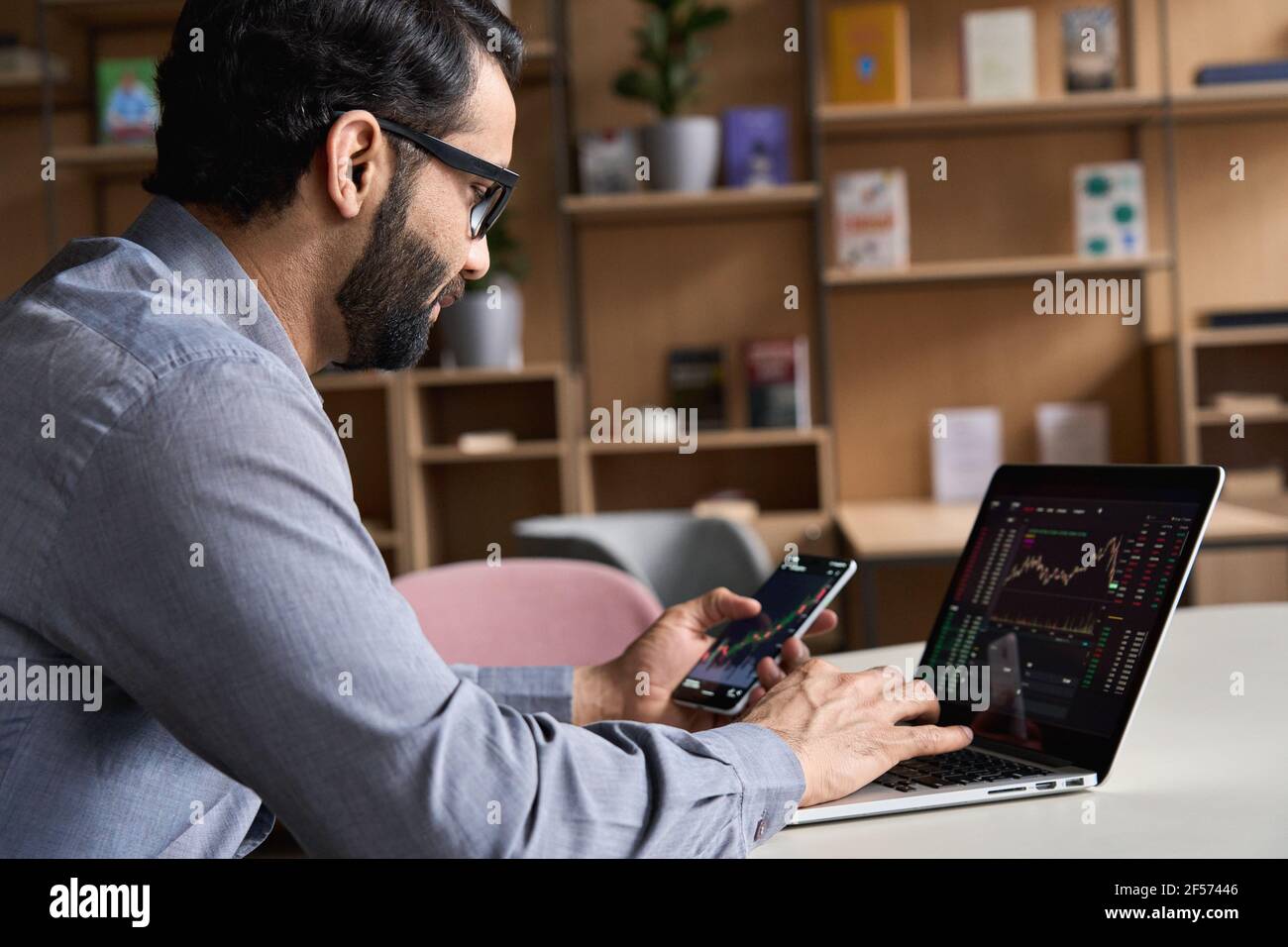 Indian business man trader investor analyst looking at financial market charts. Stock Photo