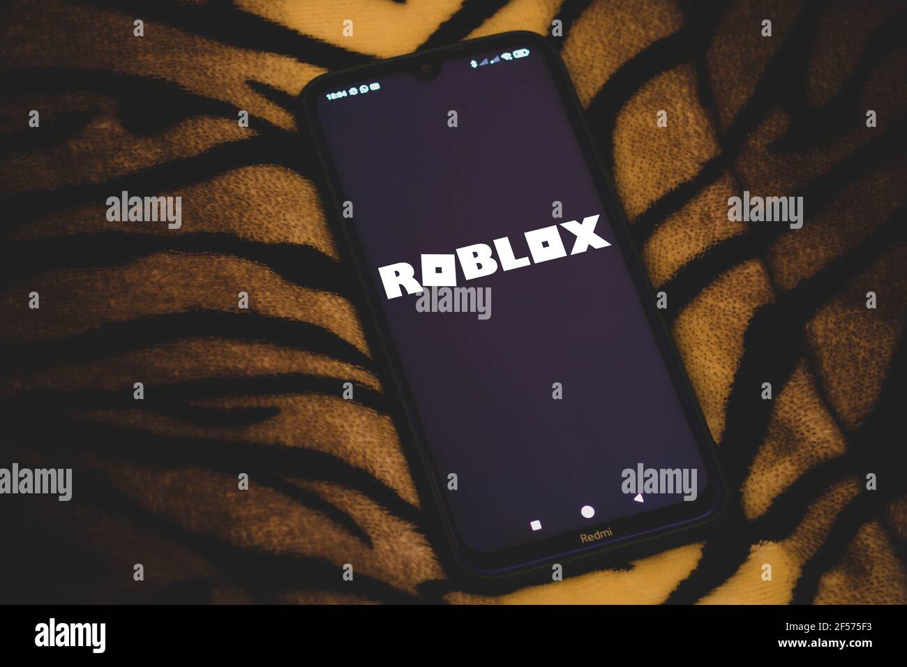 Roblox Logo and App on a Mobile Screen in a Hand Editorial Stock