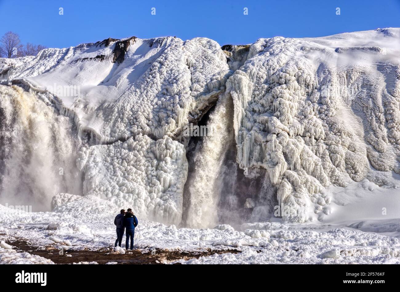 People looking at the spring thaw starting at the frozen Chutes de la Chaudière in Quebec City, Canada Stock Photo