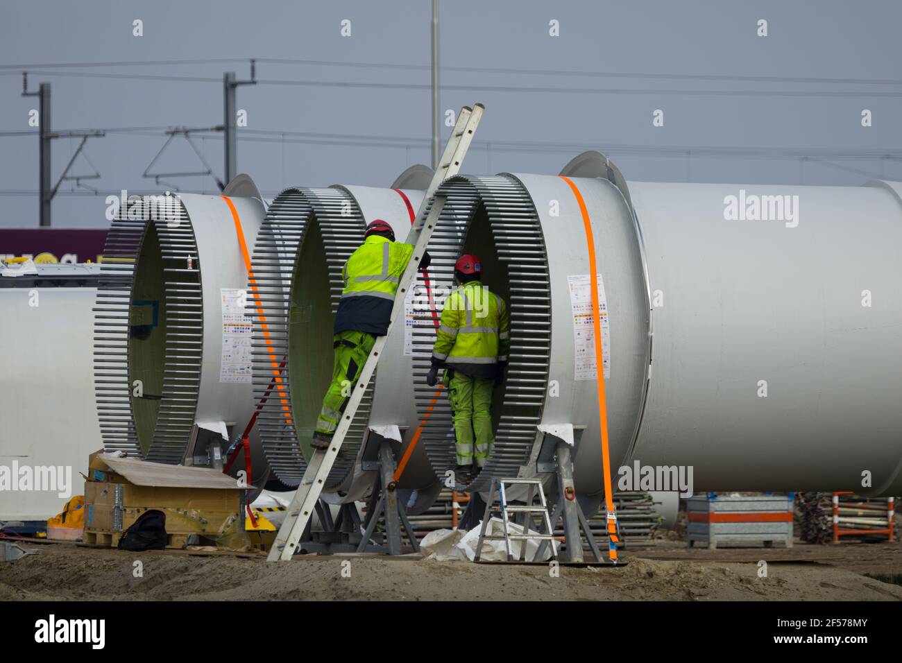 Construction workers preparing the rotor blades of a new wind turbine. Stock Photo