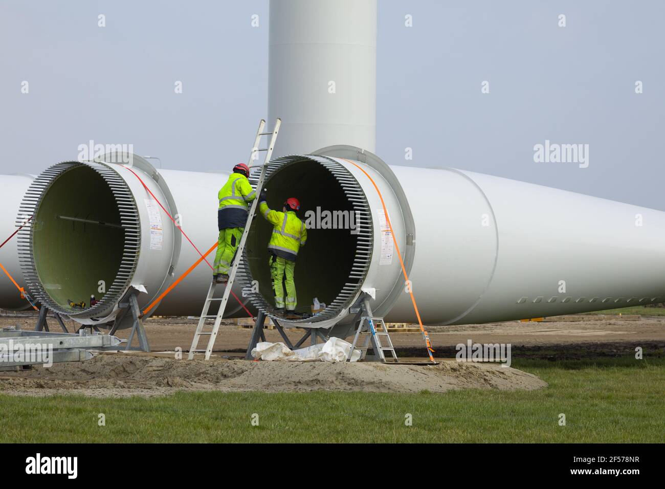 Construction workers preparing the rotor blades of a new wind turbine. Stock Photo