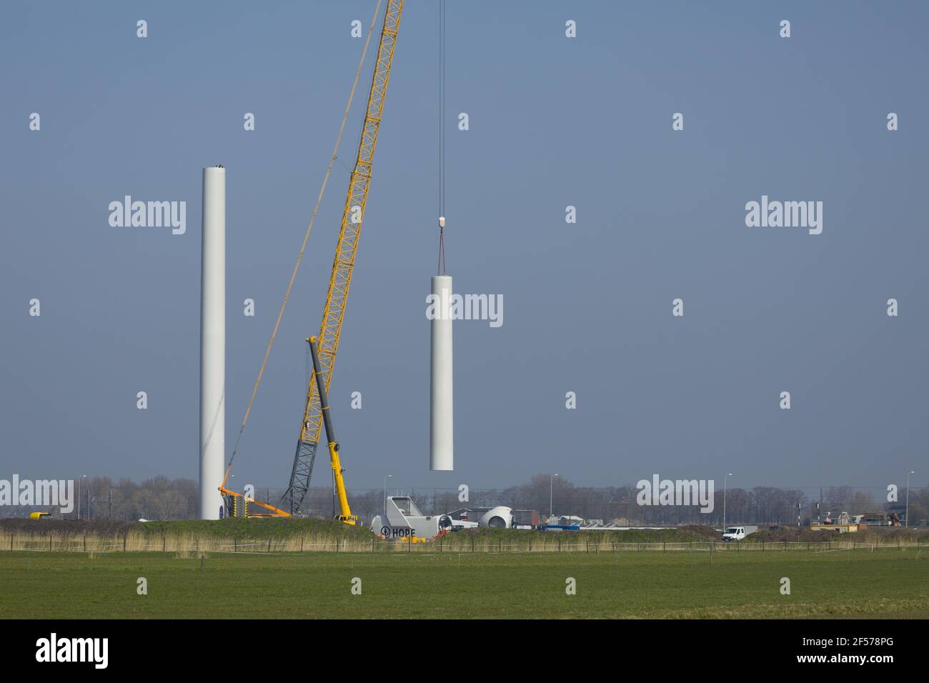 A crawler crane is hoisting the tower of a new wind turbine Stock Photo