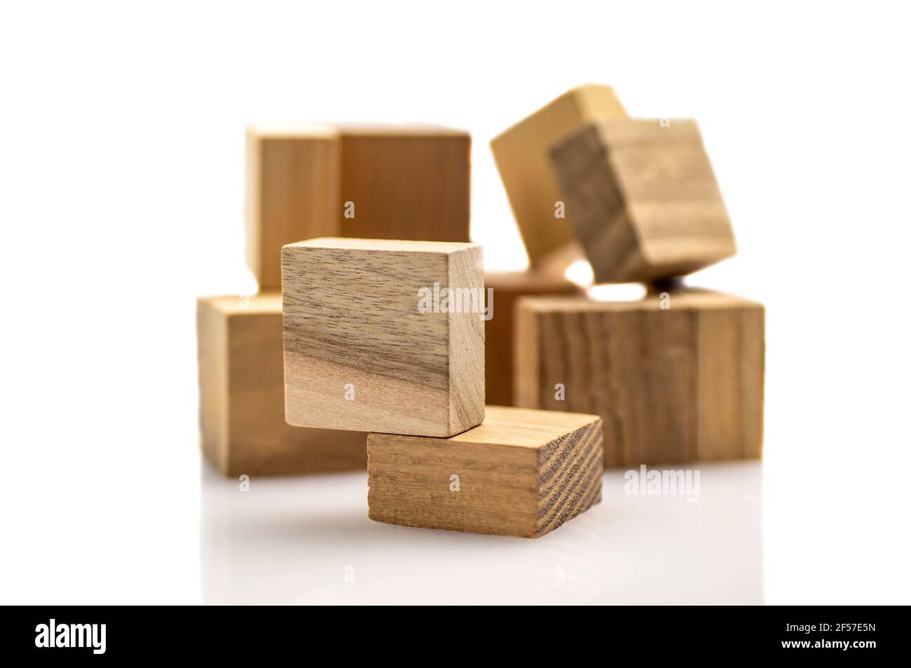 Piece of wooden puzzle close-up isolated on white background, on defocused pyramid. Business success concept. Layout for presentation. Stock Photo