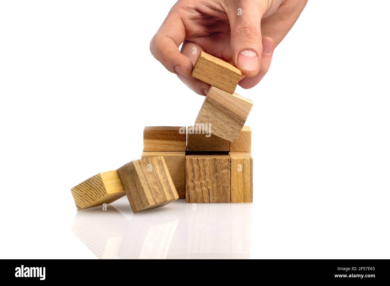man's hand adds the last missing piece of the wooden puzzle in place. Business success concept. Layout for presentation. Stock Photo