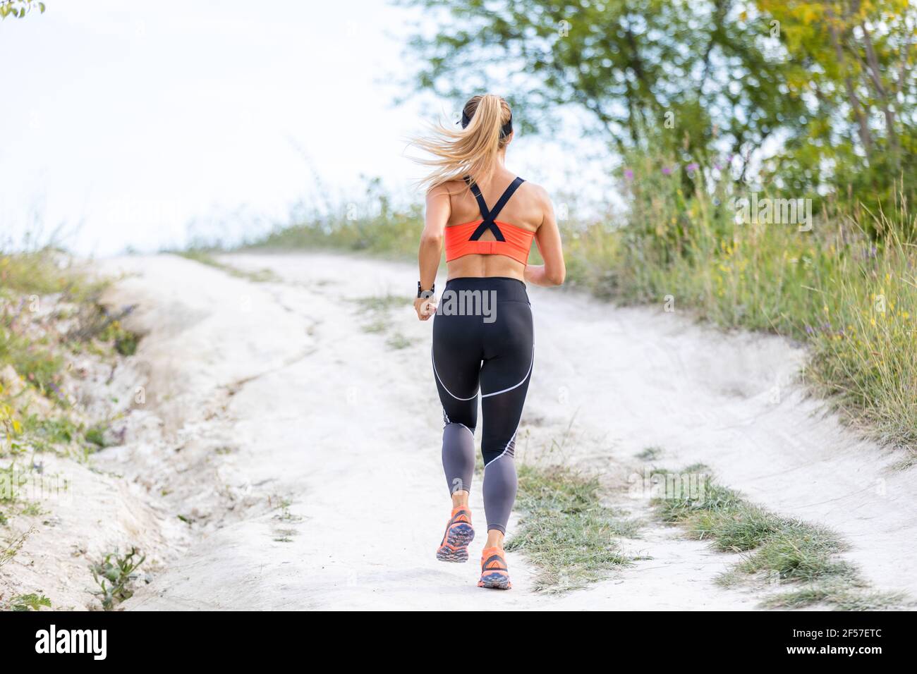 Young fitness woman running on the country road Stock Photo