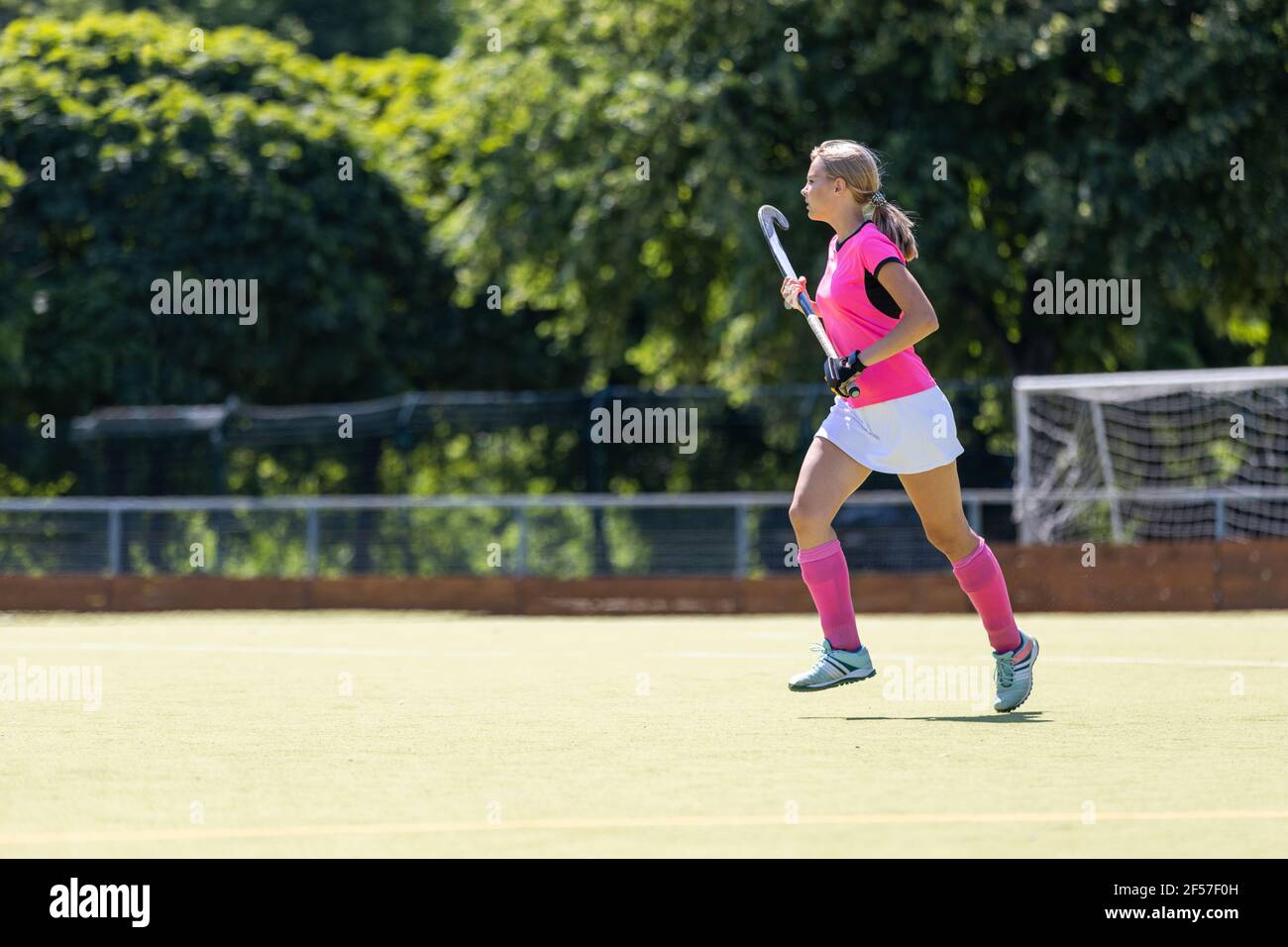 Young girl field hockey player running on pitch Stock Photo Alamy