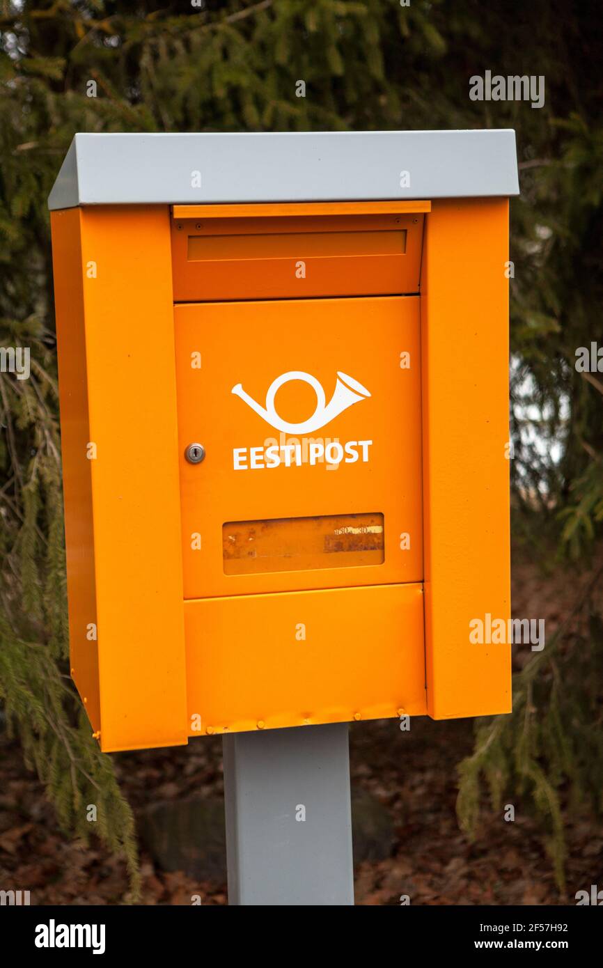 Orange postbox with old logotype of Estonian Post is on stand in  countryside still. From the 2014 it has adopted new logo and name the Omniva.  Estonia Stock Photo - Alamy