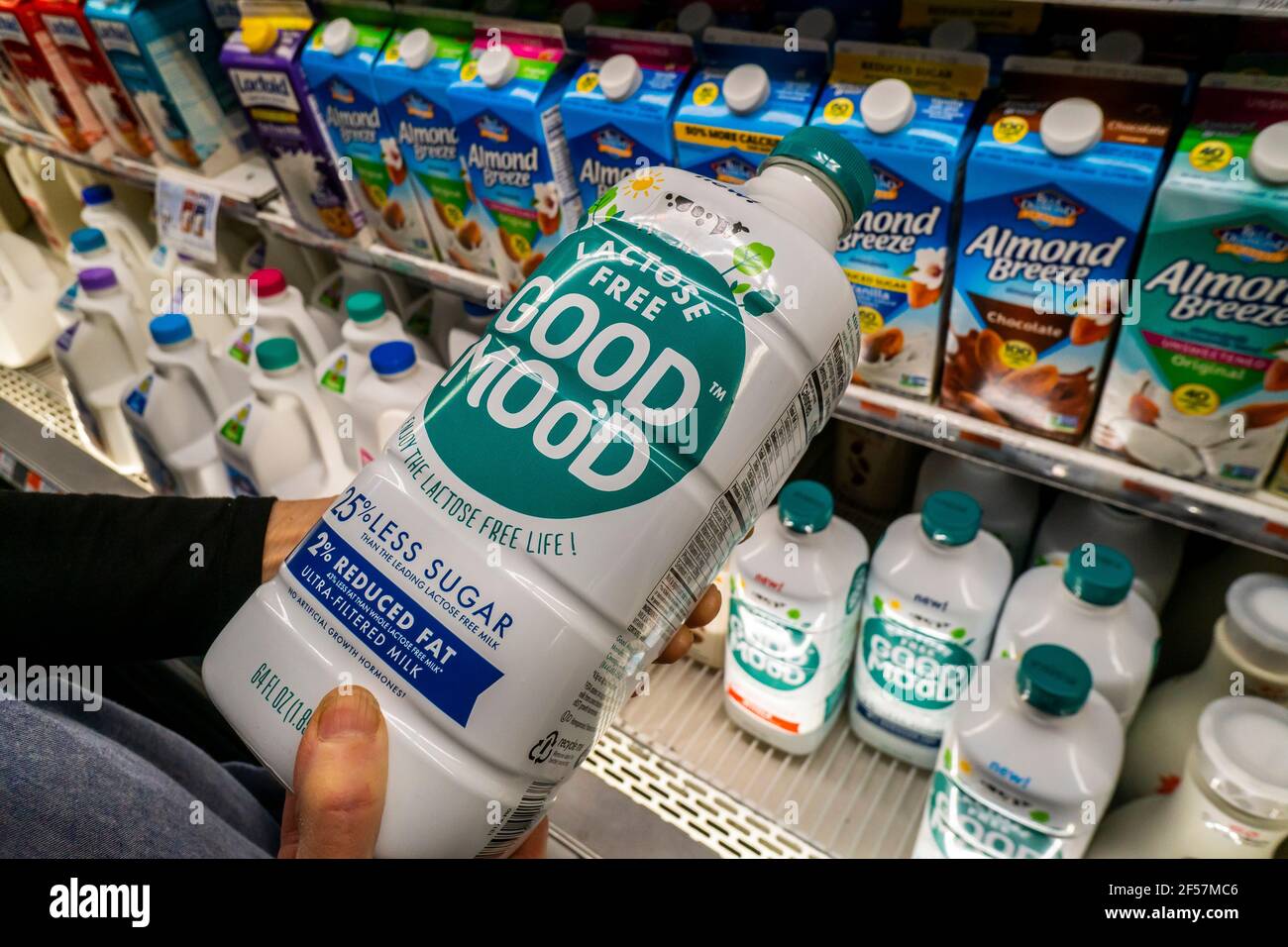 A shopper with a container of Coca-Cola's Good Moo’d premium lactose free 'supermilk' in a supermarket in New York on Thursday, March 11, 2021. The premium beverage is lactose-free and contains 25% less sugar than regular lactose-free milk. Coca-Cola was in partnership with Select Milk Producers, maker of Fairlife from its inception in 2012 and acquired the company 2020. It also costs about twice as much as regular milk. (© Richard B. Levine) Stock Photo