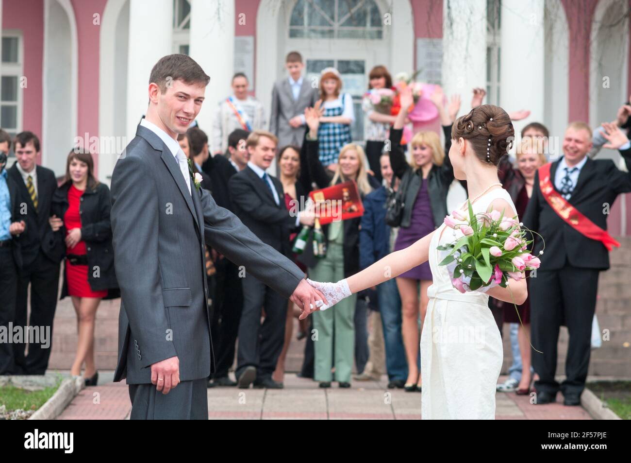 Petrozavodsk, Russia-circa May, 2010: Newlywed couple with members of the wedding stand on stairs of palace. The end of registration with guests congr Stock Photo