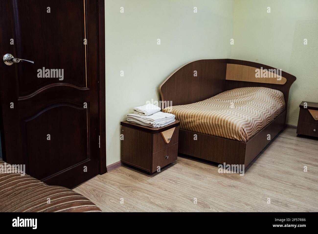 a room in a cheap hotel. minimalistic interior of an economy class hotel room. overnight stay for the traveler. several beds and a table Stock Photo