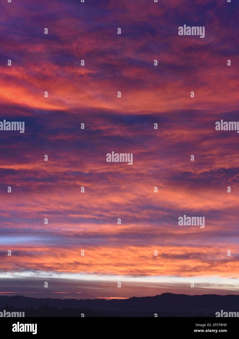 Epic scene of a cloudy sky during sunrise with purple and pink colors Stock Photo